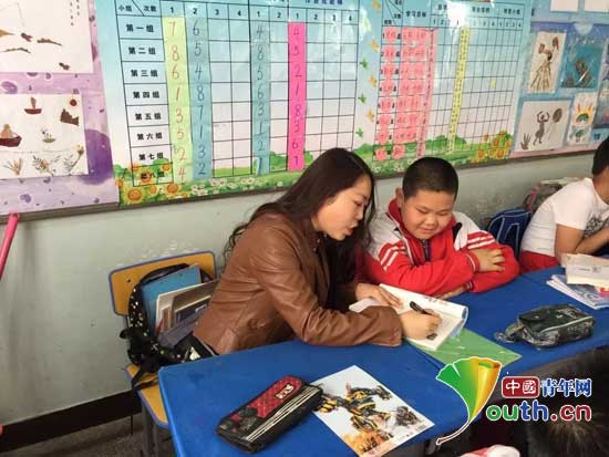 图为KY开元集团官网研支团成员在辅导学生功课。KY开元集团官网研支团 供图